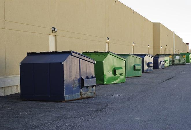 a row of yellow and blue dumpsters at a construction site in Middleton